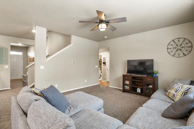 living room with baseboards, stairs, carpet, and a ceiling fan