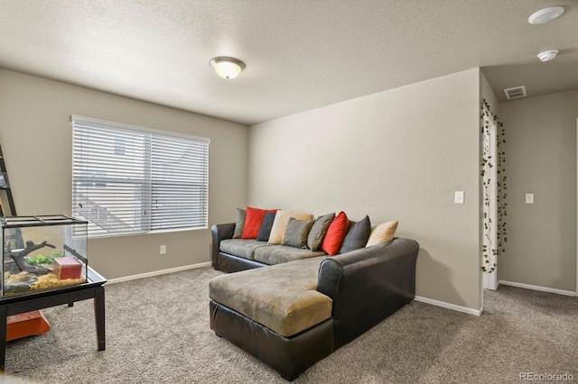 carpeted living room with visible vents, a textured ceiling, and baseboards