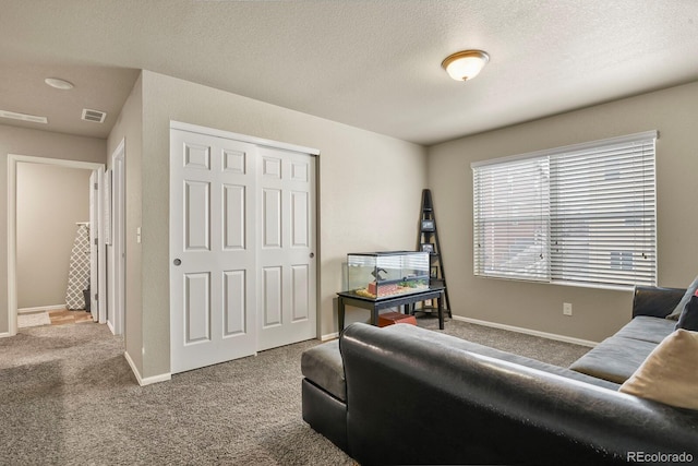 living room featuring carpet flooring, baseboards, visible vents, and a textured ceiling