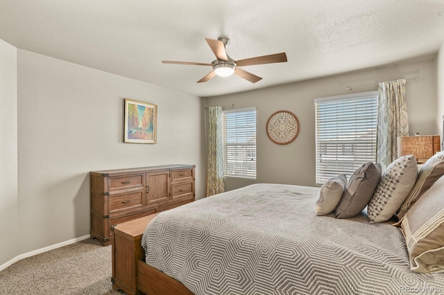 carpeted bedroom featuring baseboards, a textured ceiling, and ceiling fan