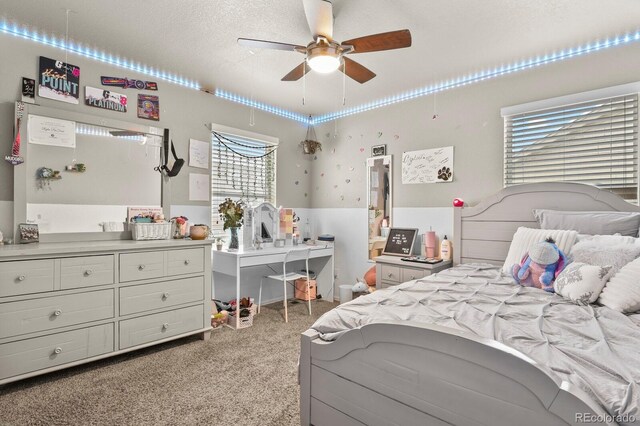 bedroom with light colored carpet, a textured ceiling, and a ceiling fan