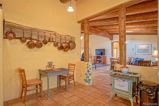 tiled dining room featuring beamed ceiling and decorative columns