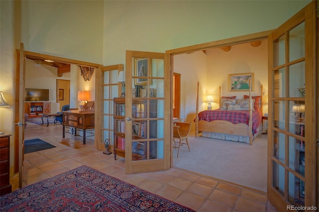 bedroom with carpet flooring, french doors, and a high ceiling