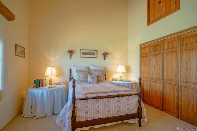 carpeted bedroom featuring a towering ceiling