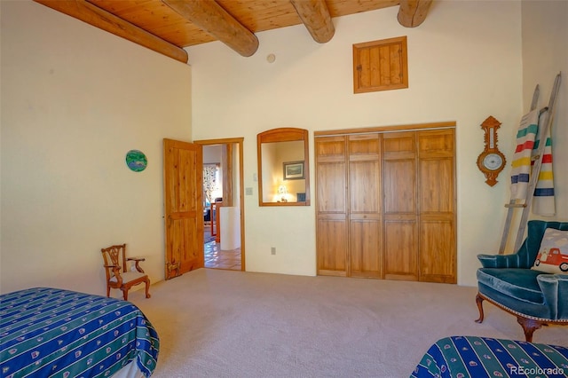 bedroom featuring beamed ceiling, carpet, a high ceiling, and wood ceiling