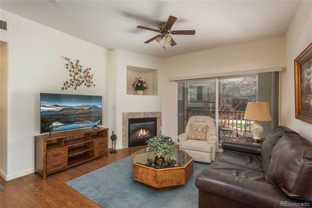 8775 W Berry Ave Unit 101, Littleton, CO 80123 - living area with visible vents, baseboards, wood finished floors, ceiling fan, and a tile fireplace