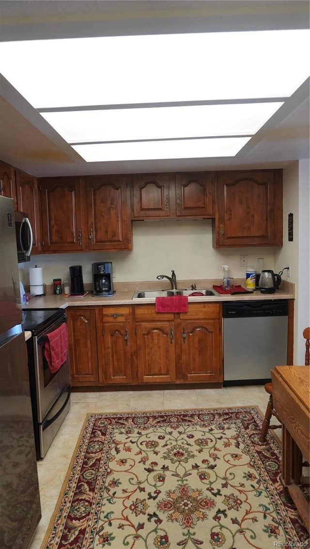 kitchen featuring sink, light tile patterned floors, and stainless steel appliances