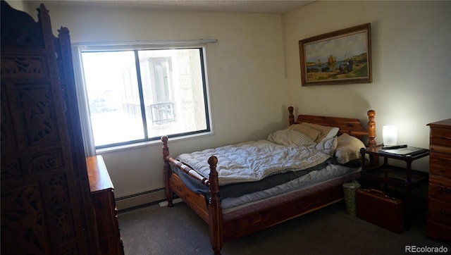 bedroom with dark colored carpet and baseboard heating