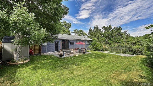 12020 W Alabama Pl, Lakewood, CO 80228 - view of grassy yard with a patio area and a storage unit