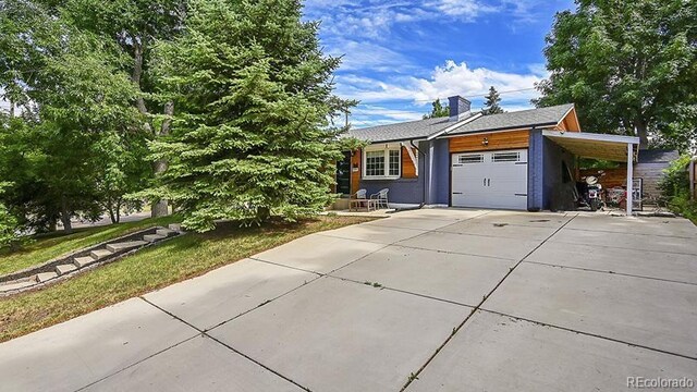 12020 W Alabama Pl, Lakewood, CO 80228 - view of front of house featuring driveway, a garage, a carport, and a chimney