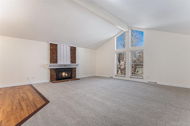 unfurnished living room with carpet, vaulted ceiling with beams, and a brick fireplace