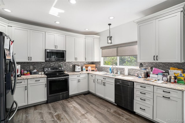 1201 102nd Ave, Greeley, CO 80634 - kitchen with dishwasher, black range with electric stovetop, stainless steel microwave, freestanding refrigerator, and backsplash