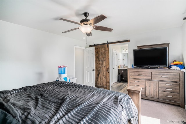 1201 102nd Ave, Greeley, CO 80634 - bedroom with a barn door, a ceiling fan, and connected bathroom
