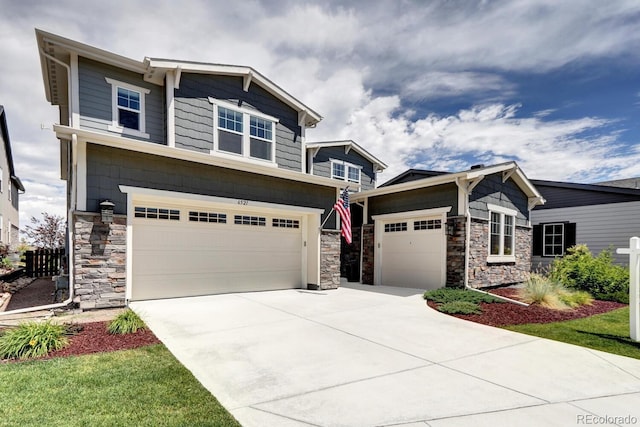 craftsman house with an attached garage, driveway, and stone siding