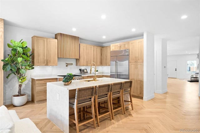 kitchen featuring recessed lighting, light brown cabinets, appliances with stainless steel finishes, and a sink