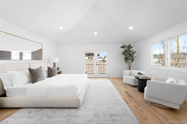 bedroom featuring light wood finished floors, multiple windows, french doors, and access to outside