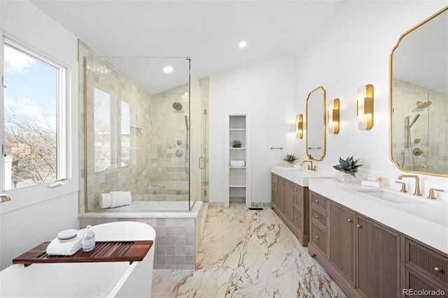 full bathroom with a freestanding bath, lofted ceiling, a stall shower, marble finish floor, and a sink