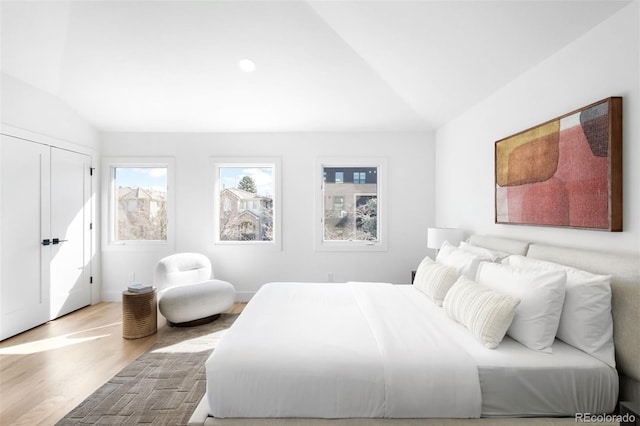 bedroom with wood finished floors and vaulted ceiling