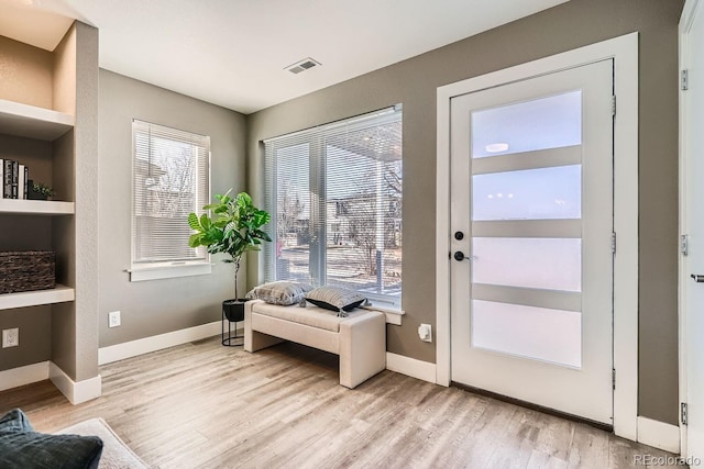 entryway with built in features and light hardwood / wood-style floors