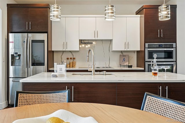 3941 Vallejo St, Denver, CO 80211 - kitchen featuring stainless steel appliances, a sink, dark brown cabinetry, white cabinets, and hanging light fixtures