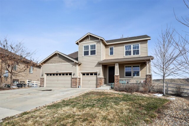 craftsman-style home featuring driveway, stone siding, fence, a garage, and a porch