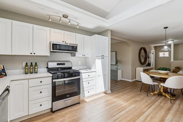 1895 S Emerson St, Denver, CO 80210 - kitchen featuring stainless steel appliances, white cabinets, light countertops, light wood finished floors, and crown molding