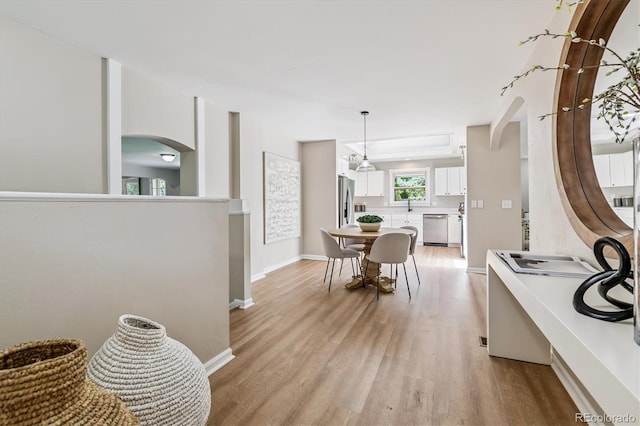 1895 S Emerson St, Denver, CO 80210 - dining space with arched walkways and light wood-style flooring
