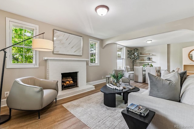 1895 S Emerson St, Denver, CO 80210 - living area featuring wood finished floors, a brick fireplace, and healthy amount of natural light