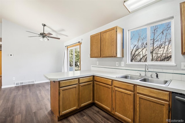 kitchen featuring kitchen peninsula, dark hardwood / wood-style flooring, ceiling fan, sink, and dishwasher