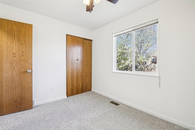 unfurnished bedroom with carpet, ceiling fan, and a closet