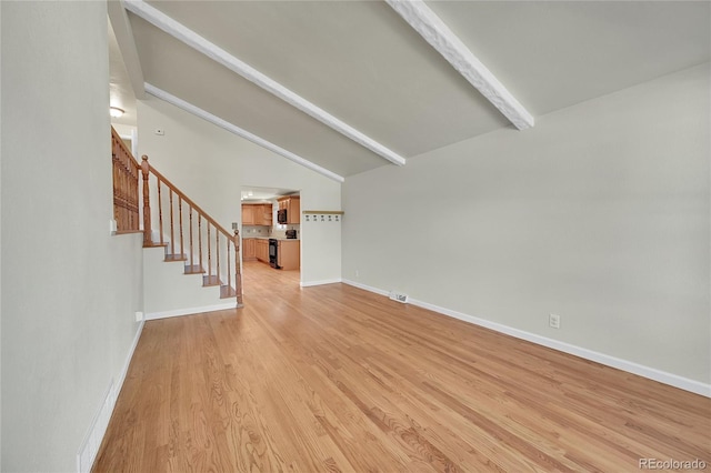 7240 S Cherry Dr, Centennial, CO 80122 - unfurnished living room featuring lofted ceiling with beams, light wood-style flooring, visible vents, baseboards, and stairs