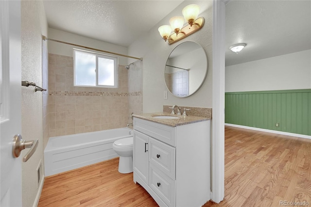 7240 S Cherry Dr, Centennial, CO 80122 - bathroom with toilet, wood finished floors, vanity, shower / washtub combination, and wainscoting