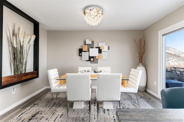 dining space with hardwood / wood-style floors and a chandelier