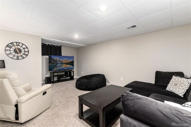 carpeted living room with a drop ceiling