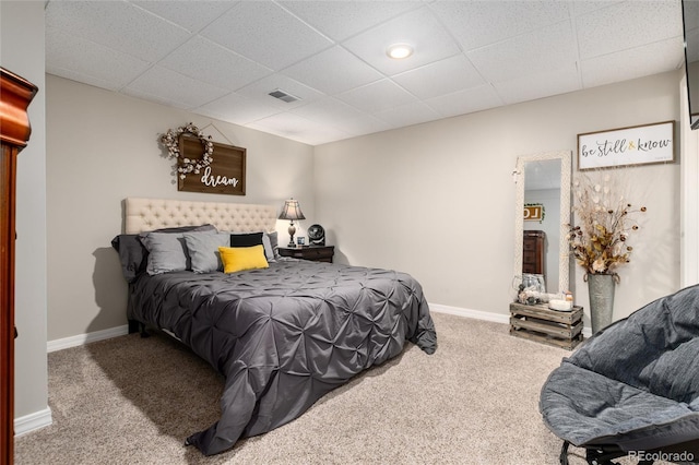 bedroom with carpet floors and a drop ceiling