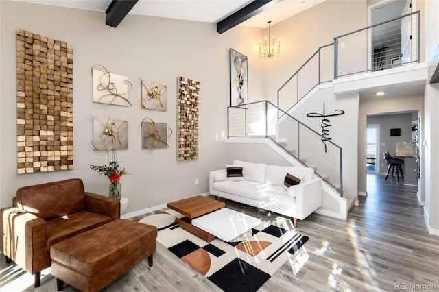 living room with hardwood / wood-style floors, beam ceiling, a notable chandelier, and a towering ceiling