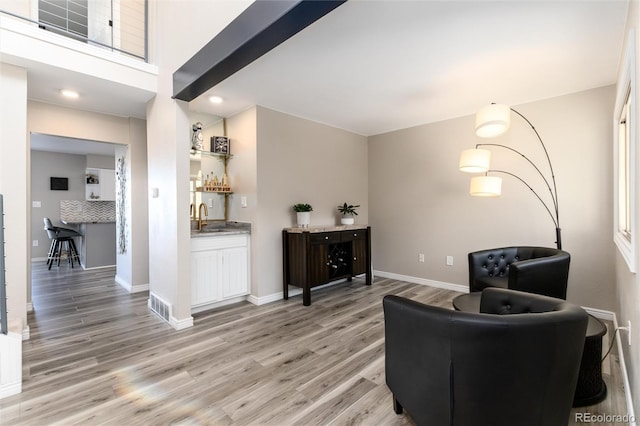 living area with wet bar and light hardwood / wood-style floors