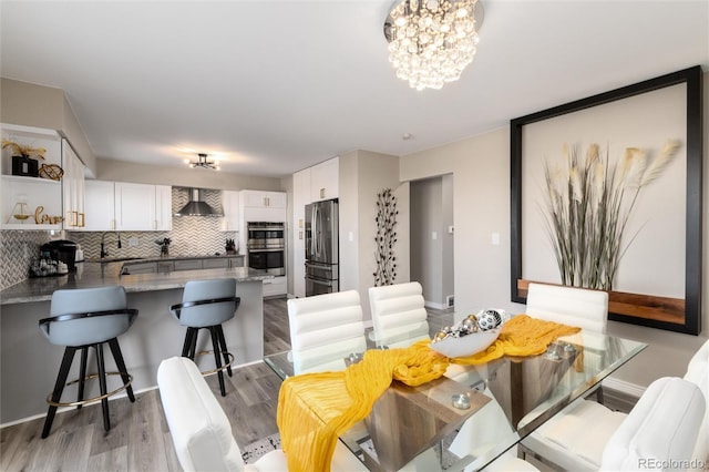 dining area with sink, a chandelier, and hardwood / wood-style floors