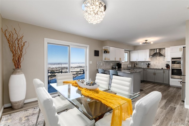 dining area with plenty of natural light, hardwood / wood-style floors, and a notable chandelier