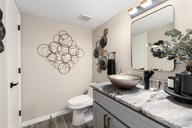 bathroom featuring vanity, hardwood / wood-style floors, and toilet