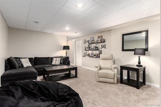 living room featuring light carpet and a drop ceiling