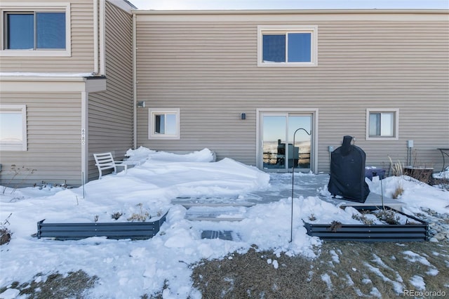 view of snow covered back of property