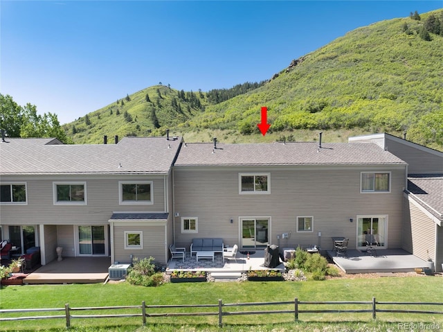 6980 Fargo Trl, Littleton, CO 80125 - back of property featuring a deck with mountain view, an outdoor living space, and a patio