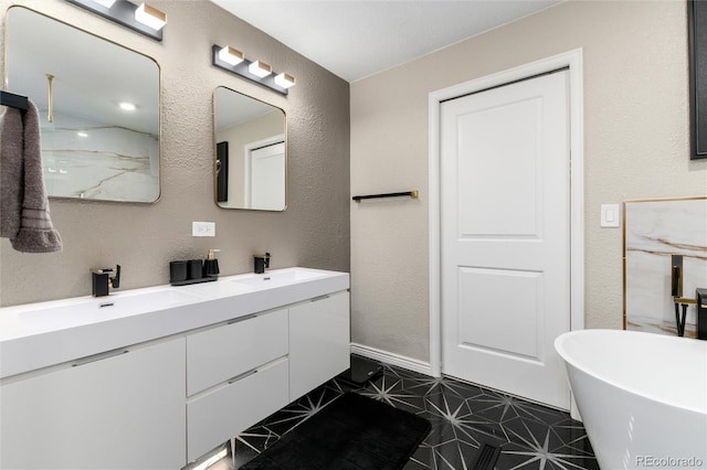6980 Fargo Trl, Littleton, CO 80125 - bathroom featuring double vanity, a freestanding bath, and a textured wall