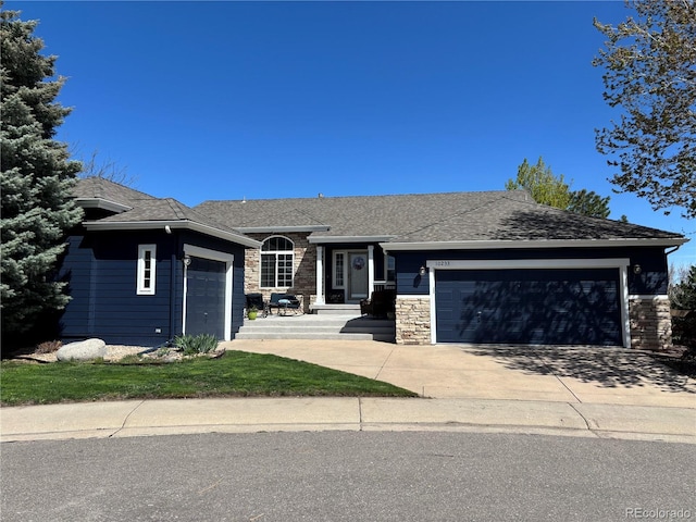 ranch-style home featuring roof with shingles, an attached garage, driveway, and stone siding