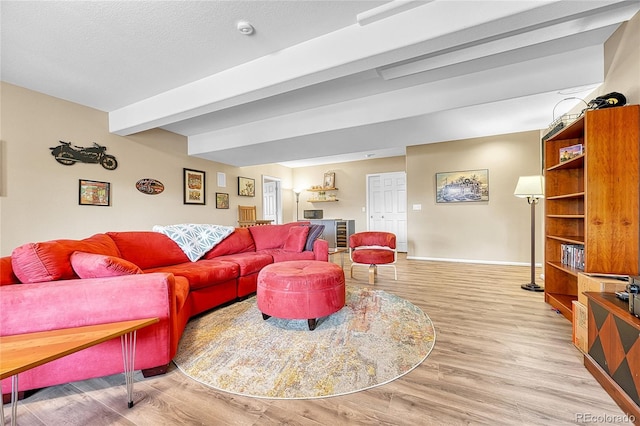 living room with baseboards, beamed ceiling, and wood finished floors