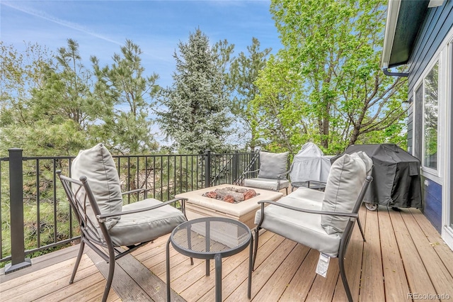 wooden terrace featuring an outdoor living space with a fire pit