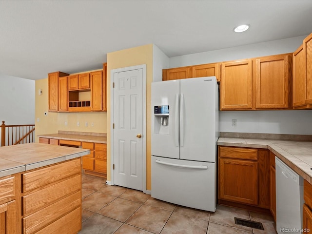 386 Monte Vista St, Brighton, CO 80601 - kitchen featuring white appliances, light tile patterned floors, open shelves, tile counters, and recessed lighting