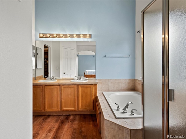 386 Monte Vista St, Brighton, CO 80601 - bathroom with a bath, double vanity, wood finished floors, and a stall shower