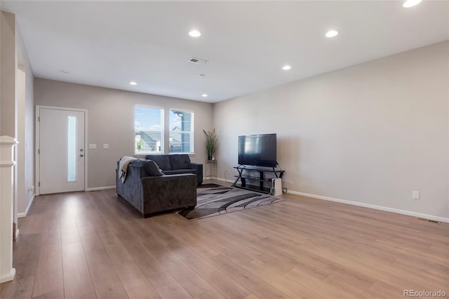 living room featuring light wood-style flooring, visible vents, and recessed lighting